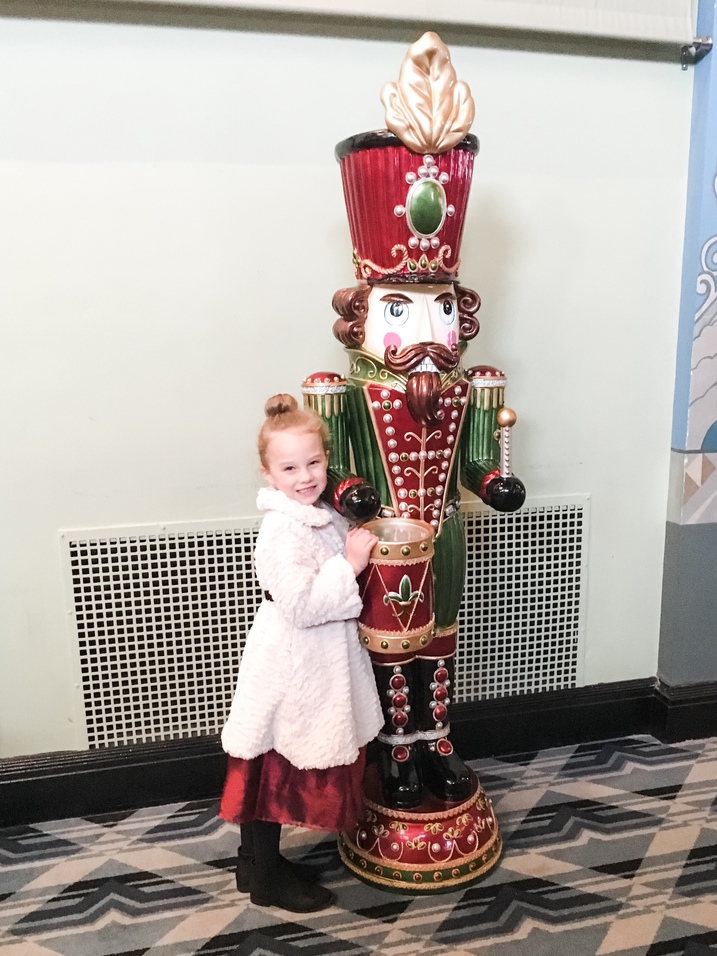 child hugging large nutcracker