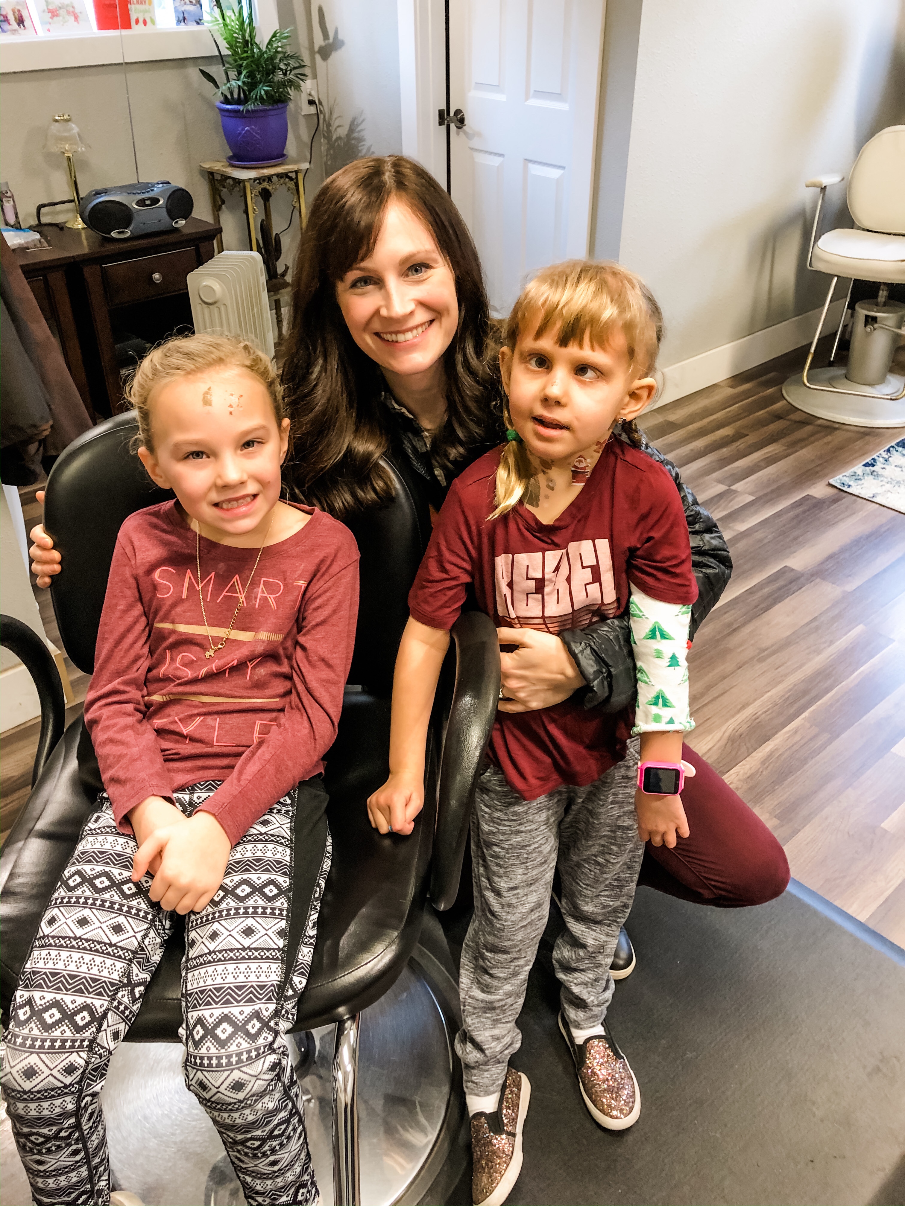 woman with daughter and niece before ear piercing at salon