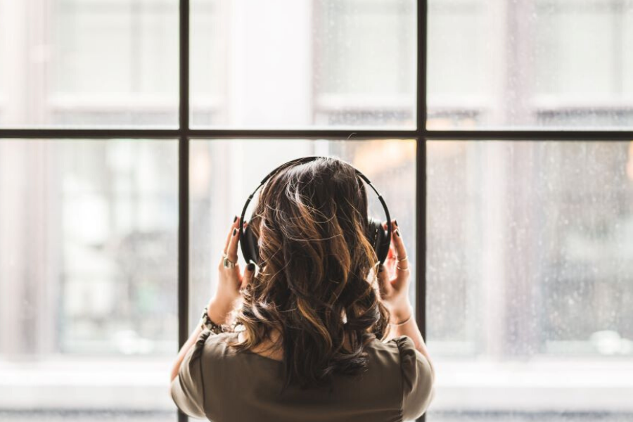 woman facing window listening to music