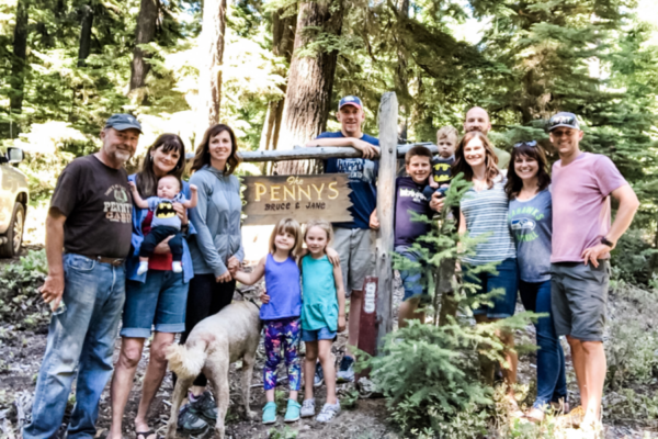 a family stands in the woods at cabin