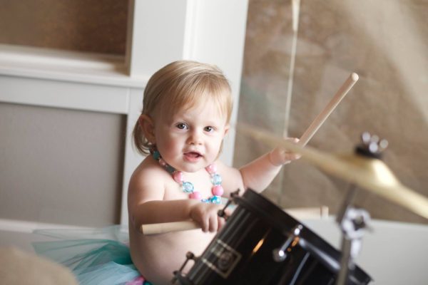 one year old sits at drum set