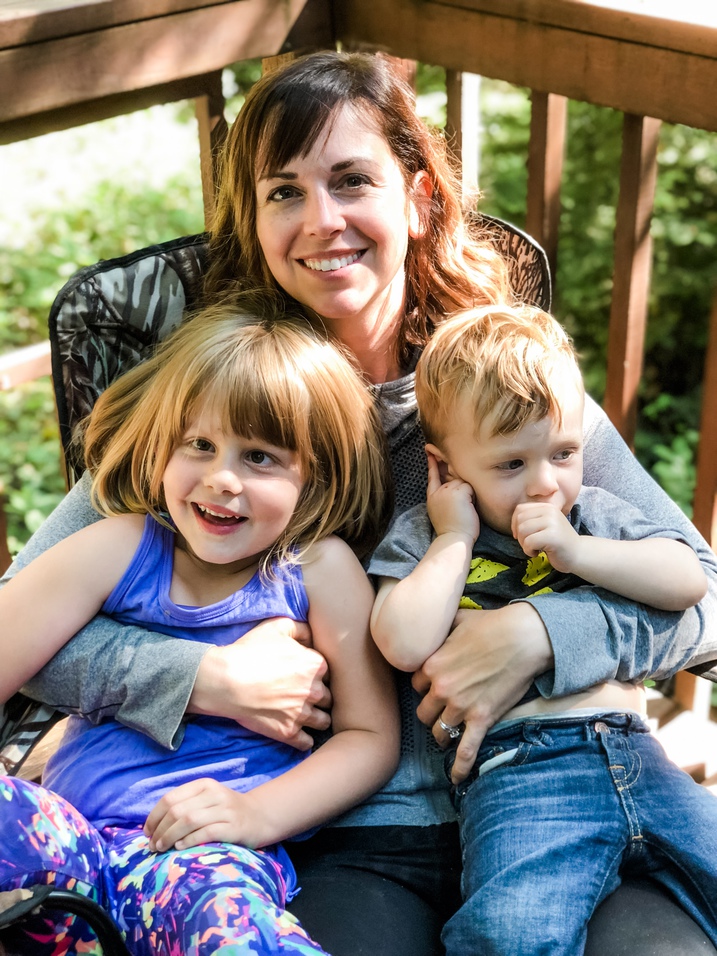 woman holds daughter and nephew in the woods